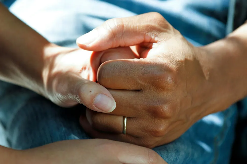 Mãos entrelaçadas em gesto de apoio